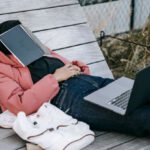 Garden Projects - Unrecognizable woman with laptop resting on bench in park