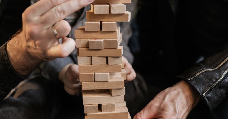 Indoor Games - Close-Up Photo of a Family Playing Jenga