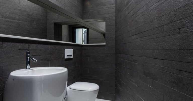 Bathroom Renovations - Contemporary bathroom interior with dark stone walls and marble styled floor